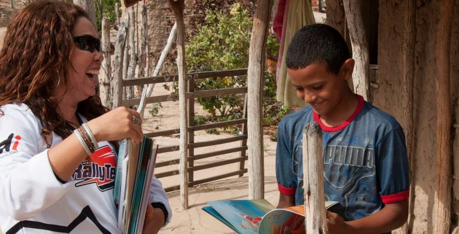 Adriana Araújo entrega um livro a um garoto da cidade cearense de Quixadá | © Divulgação