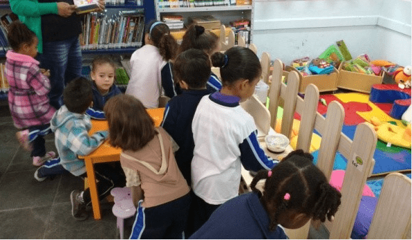 Crianças brincam na biblioteca montada pelo projeto Pequenos Leitores na cidade de Vargem, em 2015 | © Divulgação