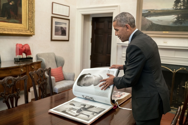 Barack Obama folheando livro sobre Muhammad Ali | © Divulgação / Pete Souza