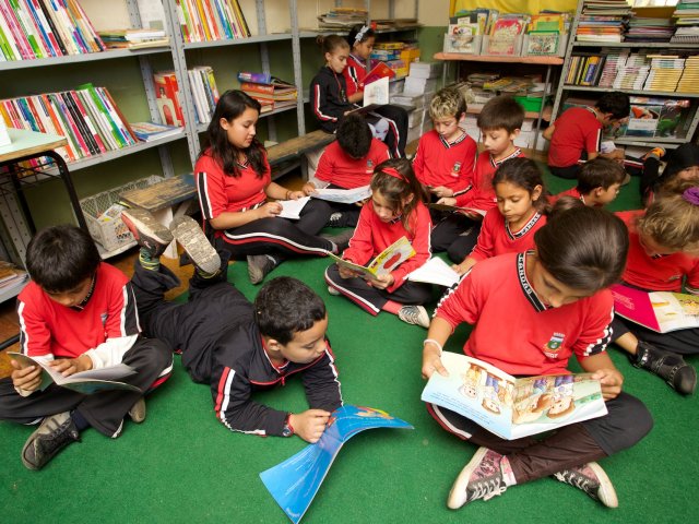 Crianças manuseiam livros em escola em Goiânia | © Ascom / FNDE