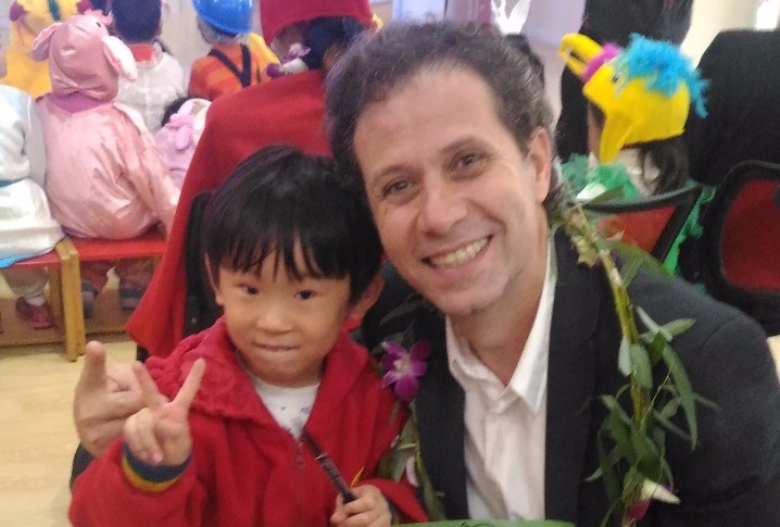 Roger Mello ao lado de um pequeno leitor chinês | © Divulgação Roger Mello ao lado de um pequeno leitor chinês | © Divulgação