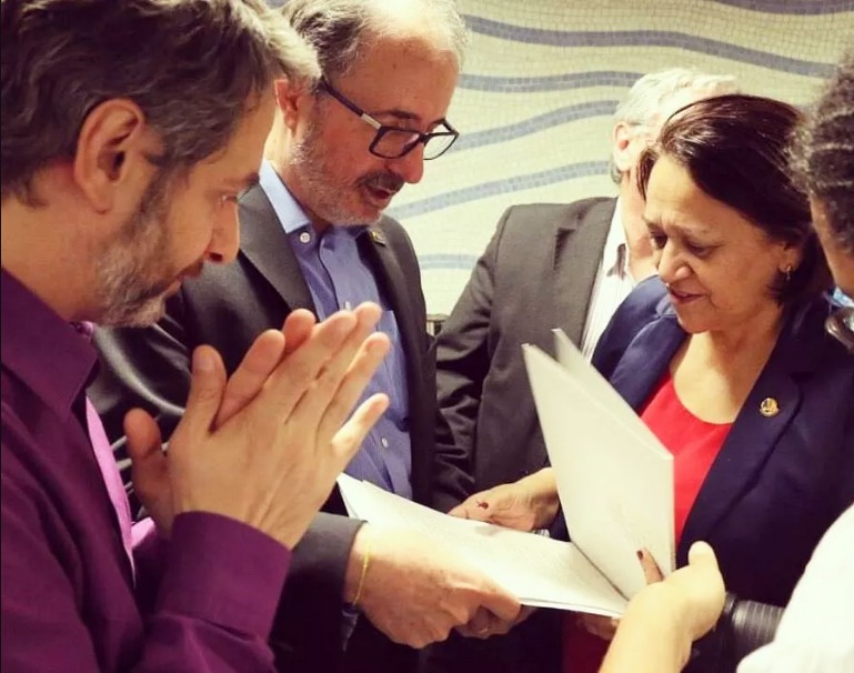 Castilho (no meio) e Volnei Canônica, então diretor do Livro, Leitura, Literatura e Bibliotecas do MinC, entregando o projeto de lei à senadora Fátima Bezerra em maio de 2016 | Assessoria do Gabinete da senadora Castilho (no meio) e Volnei Canônica, então diretor do Livro, Leitura, Literatura e Bibliotecas do MinC, entregando o projeto de lei à senadora Fátima Bezerra em maio de 2016 | Assessoria do Gabinete da senadora
