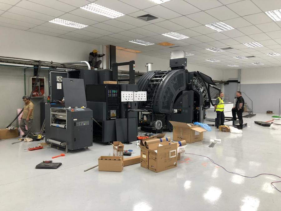 Work in progress: equipe instala novo equipamento com o qual a gráfica espera dobrar sua capacidade de produção | © Divulgação