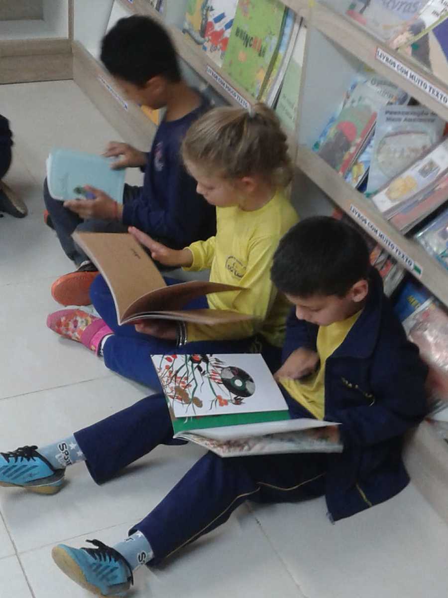 Crianças lendo na Biblioteca da Escola Municipal de Ensino Fundamental Santa Lúcia (Caxias do Sul - RS)