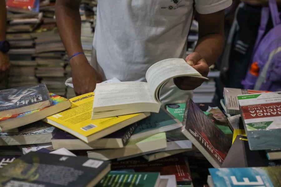 Jovem seleciona livros num dos estandes da Bienal do Livro Rio | © Rafael Catarcione / Prefeitura do Rio