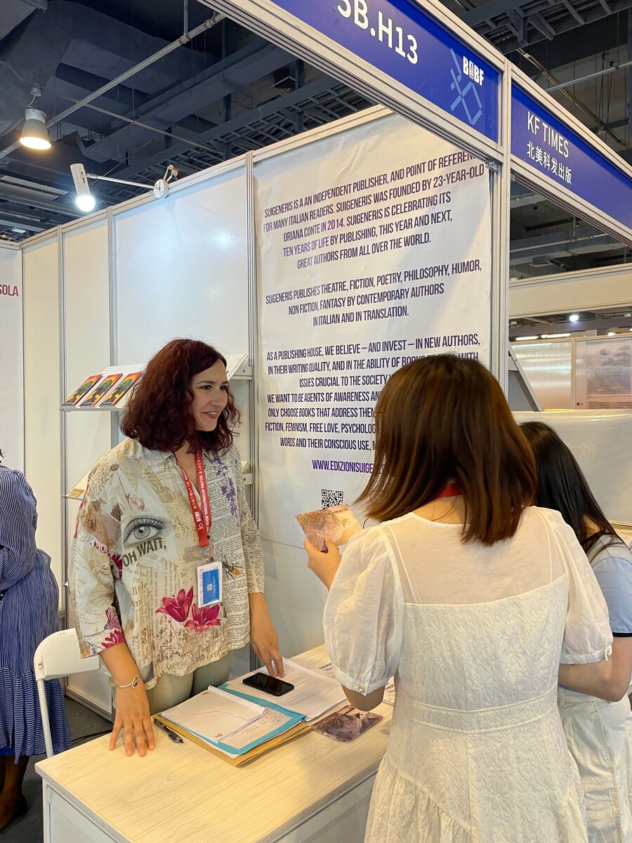 Editora italiana Oriana Conte atende passantes na BIBF 2024 | © Guilherme Sobota/PublishNews Editora italiana Oriana Conte atende passantes na BIBF 2024 | © Guilherme Sobota/PublishNews