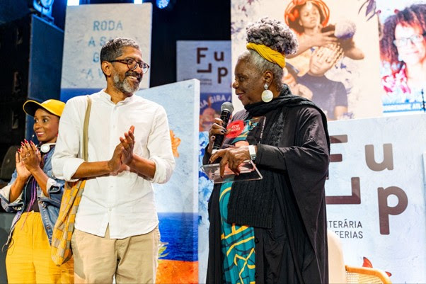 Conceição Evaristo (à direita) ao lado do escritor Jeferson Tenório (à esquerda) durante a edição deste ano, no Circo Voador (RJ); ela será a homenageada do festival em 2025 | © Hildemar Terceiro / Flup