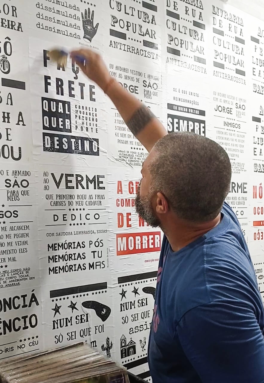 Guilherme fixando cartazes &copy; Divulgação